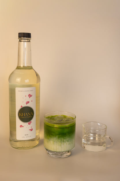 Khana Rose Syrup 750mL bottle next to a glass of matcha latte and serving of syrup